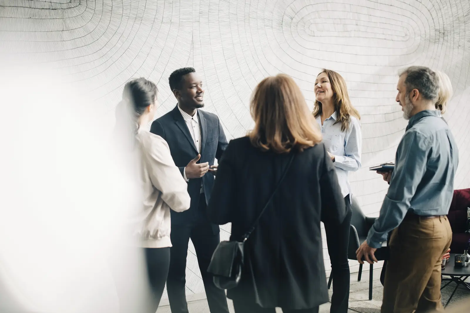 Équipe de professionnels échangeant avec convivialité, symbolisant la proximité et le réseau de partenaires Enila’s Prestige.