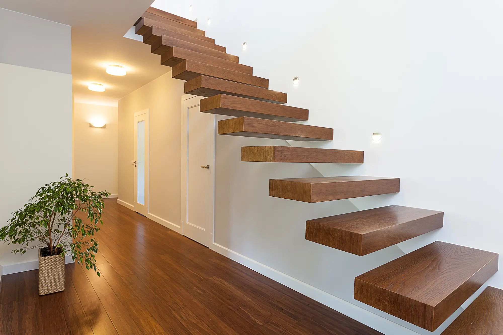 Floating solid wood staircase in a modern, minimalist interior.